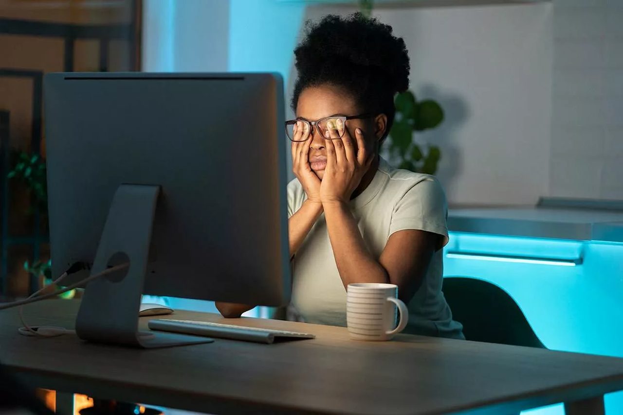 Person with tired eyes looking at a screen in dim light